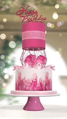 a pink and white birthday cake on top of a table