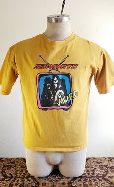 A t shirt in great condition.  It has a small hole on shoulder seam from old price tag . I love the graphics & colors.  Perfect for any Aerosmith collector. Mustard yellow in color. A vintage size medium. Aerosmith, Mustard Yellow, Mtv, Gender Neutral, Mens Graphic Tshirt, Bathing Beauties, Tops & Tees, Adult Outfits, Top Outfits