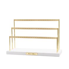 a white and gold shelf with three shelves