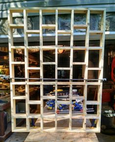 a large wooden structure sitting in the middle of a garage filled with tools and supplies