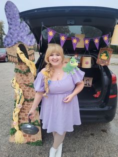 a woman standing in front of a car with her trunk open and decorations on the back