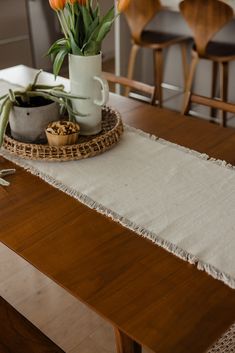 some flowers are in a white vase on a wooden table with a doily around it