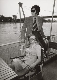 a man and woman sitting next to each other on a boat