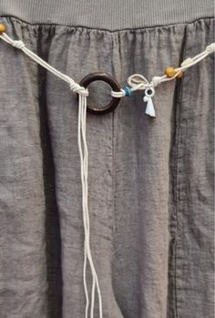 a close up of a person's pants with rings and tassels on them