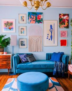 a living room with blue couches and pictures on the wall above them, including a chandelier