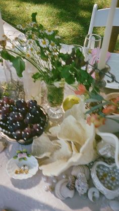 a table topped with lots of plates and bowls filled with fruit on top of it