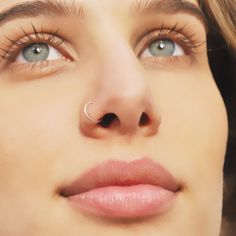 a close up of a woman's nose with a nose ring on her nose