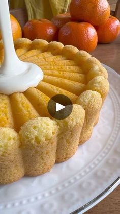 a cake with oranges in the background and a white icing drizzle on top