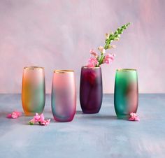 three different colored vases with flowers in them