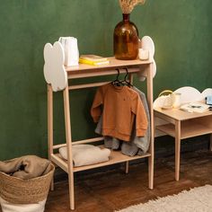 a wooden shelf with clothes on it next to a basket