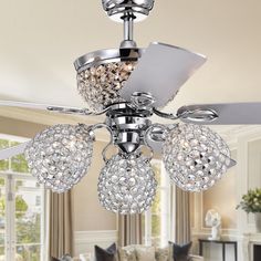 a ceiling fan with crystal balls hanging from it's blades in a living room