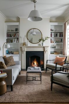 a living room filled with furniture and a fire place in the middle of the room