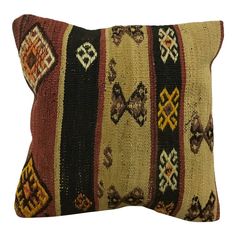 a decorative pillow with multicolored stripes and diamond shapes on the front, along with a black background