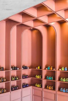 the shelves are filled with different types of items in pink and orange colors, including teas