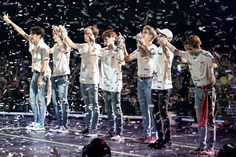 group of young men standing on stage with confetti in the air