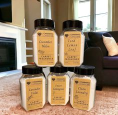 five jars of lemonade sitting on top of a counter in front of a couch