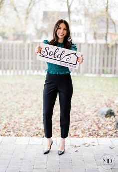 a woman holding up a sign that says sell