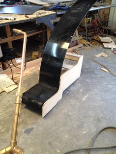 a skateboard ramp sitting on top of a wooden floor next to a metal pipe