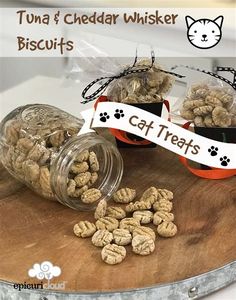 cat treats are sitting on top of a cutting board next to a glass jar filled with them