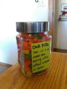 a jar filled with gummy bears sitting on top of a wooden table