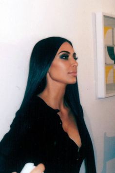 a woman with long black hair holding a white object