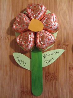 a flower made out of chocolates sitting on top of a green stick with the words valentine's day written on it