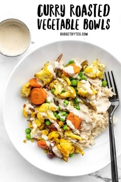 a white plate topped with cauliflower and peas next to a cup of coffee