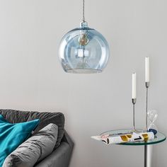 a living room with a couch, table and lamp hanging from it's ceiling