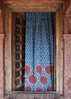 an open window with blue and red curtains