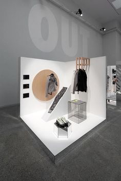 a white display case with clothes and shoes on it