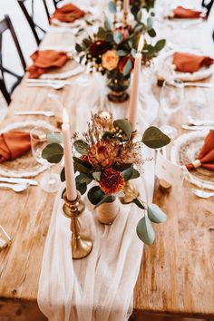 the table is set with candles, flowers and napkins for an elegant fall dinner