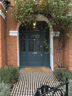 an entrance to a brick building with black and white checkered flooring