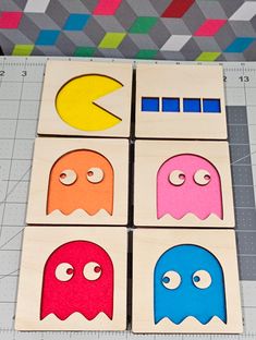 four wooden blocks with different shapes and sizes on them, one is shaped like a pacman