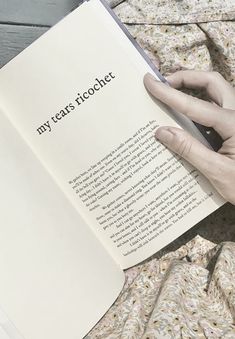 a person is reading a book on the bed