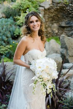 a woman in a wedding dress holding a bouquet