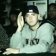 a man sitting at a table with his hands in the air