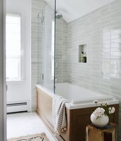 a bathroom with a bathtub, rug and window