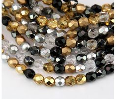 multicolored glass beads with gold and silver accents on white background, close up