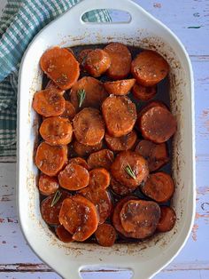 cooked carrots in a white casserole dish on a blue and white towel