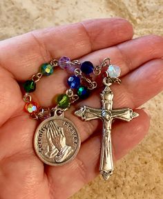 This is a beautiful one-decade Serenity prayer rosary. The total length is 8 1/4 inches. A great way to remember to pray anytime, anywhere! This will make a very meaningful gift to treasure for yourself or for someone else you really care about! Beads: I alternated an array of beautiful rainbow crystal beads for the ten Hail Marys and single Our Father. Medals: It features a 1 inch round Serenity prayer medal with the actual prayer on the reverse side. The flared Crucifix is 1 1/2 inches. The me Healing Rosary With Miraculous Medal And Round Beads, Healing Rosary With Miraculous Medal, Spiritual Beaded Rosary For Blessing, Spiritual Rosary With 8mm Beads For Blessing, Multicolor Spiritual Rosary Bracelet With 8mm Beads, Spiritual Rosary With 8mm Beads, Spiritual Rosary With 108 Beads And Crucifix, Spiritual Beaded Rosary Bracelet For Blessing, Nickel-free Spiritual Rosary Bracelet Gift