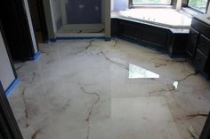 a bathroom with marble flooring and tub in it's center, surrounded by black cabinets