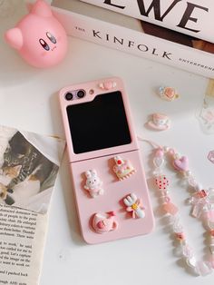 a pink cell phone case sitting on top of a table next to some beads and charms