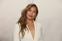 a woman in a white suit posing for the camera