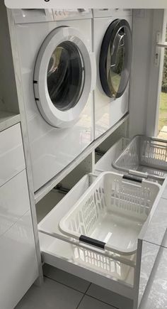 a washer and dryer sitting next to each other in a room with tile flooring