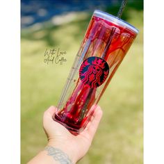 a hand holding a red and black starbucks cup