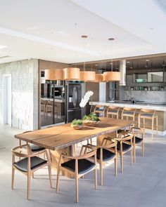 a dining room table and chairs in front of a kitchen with an island countertop