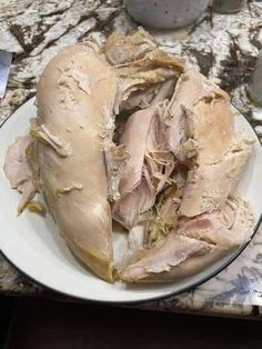 a white plate topped with meat on top of a counter