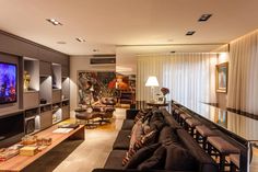 a living room filled with furniture and a large flat screen tv mounted to the wall