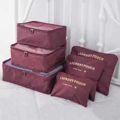 three pieces of luggage sitting on top of a bed next to pillows and pillow cases