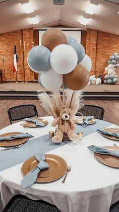 a table set with plates, silverware and balloons